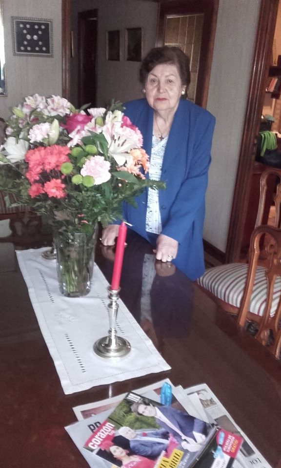 Flores para el Día de la Madre. En el comedor. Al fondo un cuadro con medallones de monumentos de León.